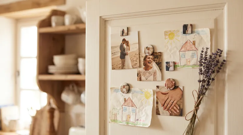 Porte de réfrigérateur avec des magnets photo de mariage et un dessin d’enfant